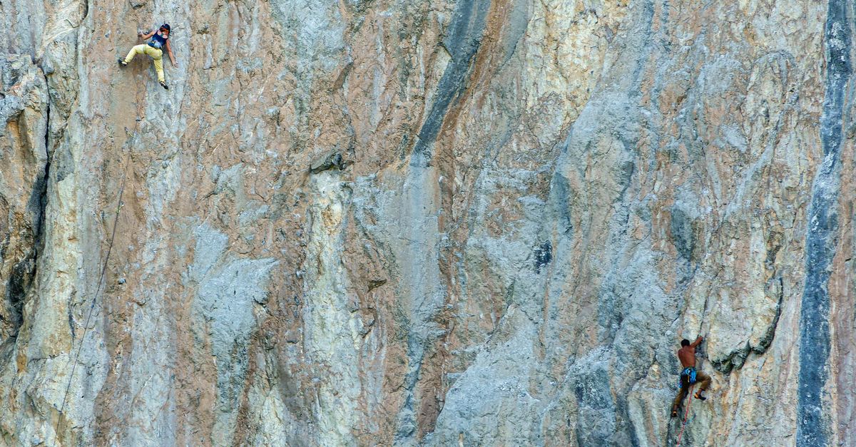 Rock climber scaling a cliff face in the mountains