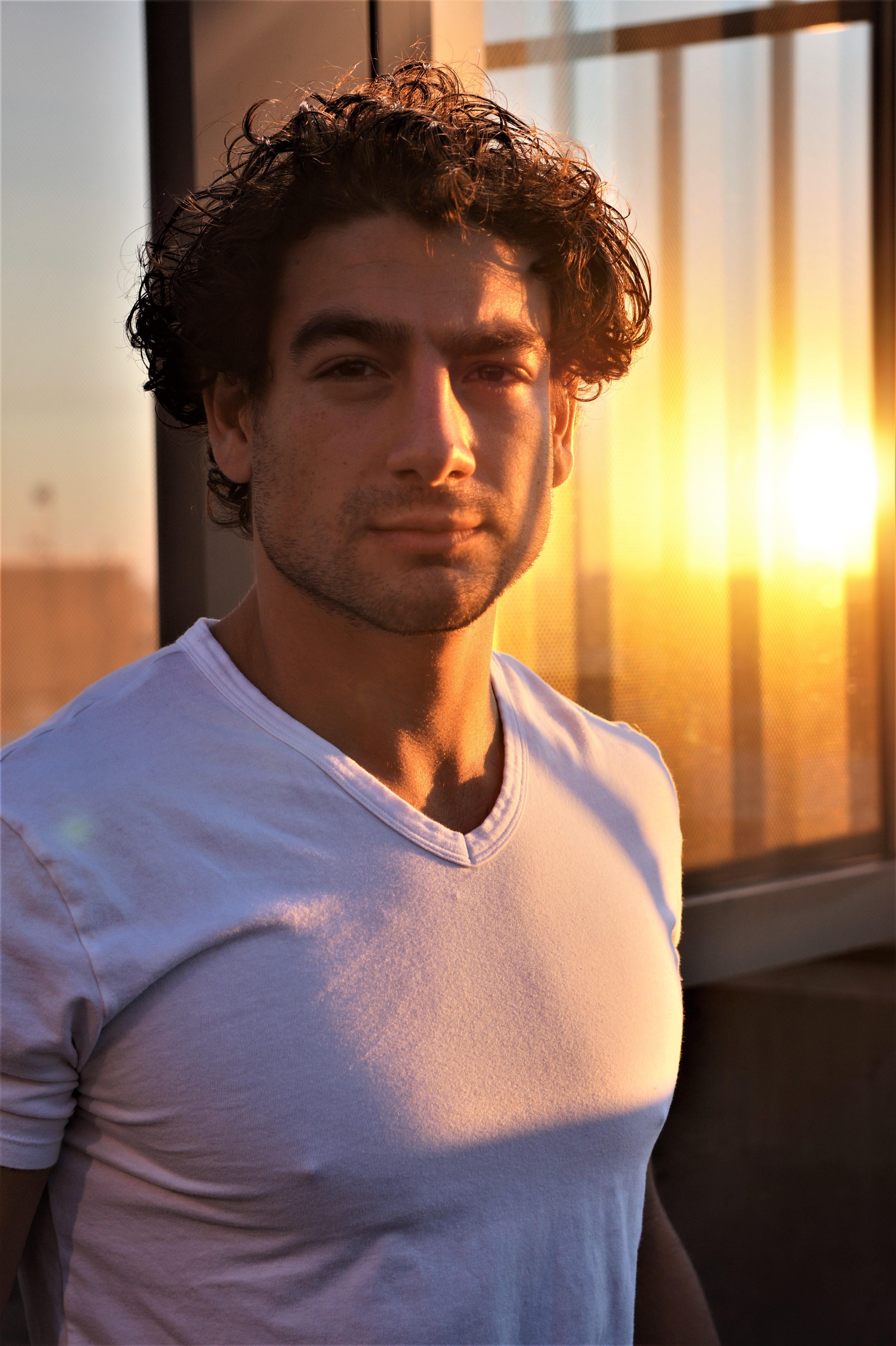 Portrait of a handsome man in casual attire with sunset lighting creating a dramatic effect.
