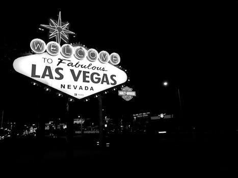 Black and white photo of the famous Las Vegas sign illuminated at night. by Kio