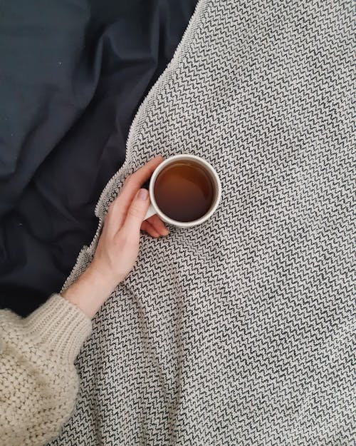 Hand Holding Cup of Tea