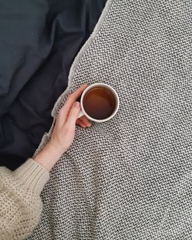 一只手握着茶杯，放在舒适的毛毯上，散发着温暖与舒适。 - 相关推荐
