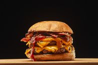 Indulge in a juicy double cheeseburger with bacon and melted cheese, perfect for food lovers.