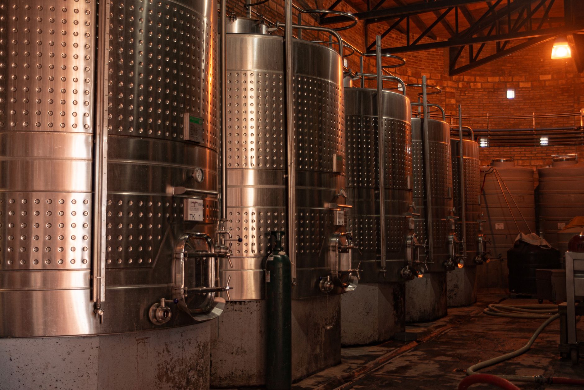 Row of stainless steel tanks in an industrial plant showcasing modern production technology.