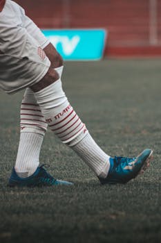 A focused view of a football player's feet wearing cleats on the field, ready for action.