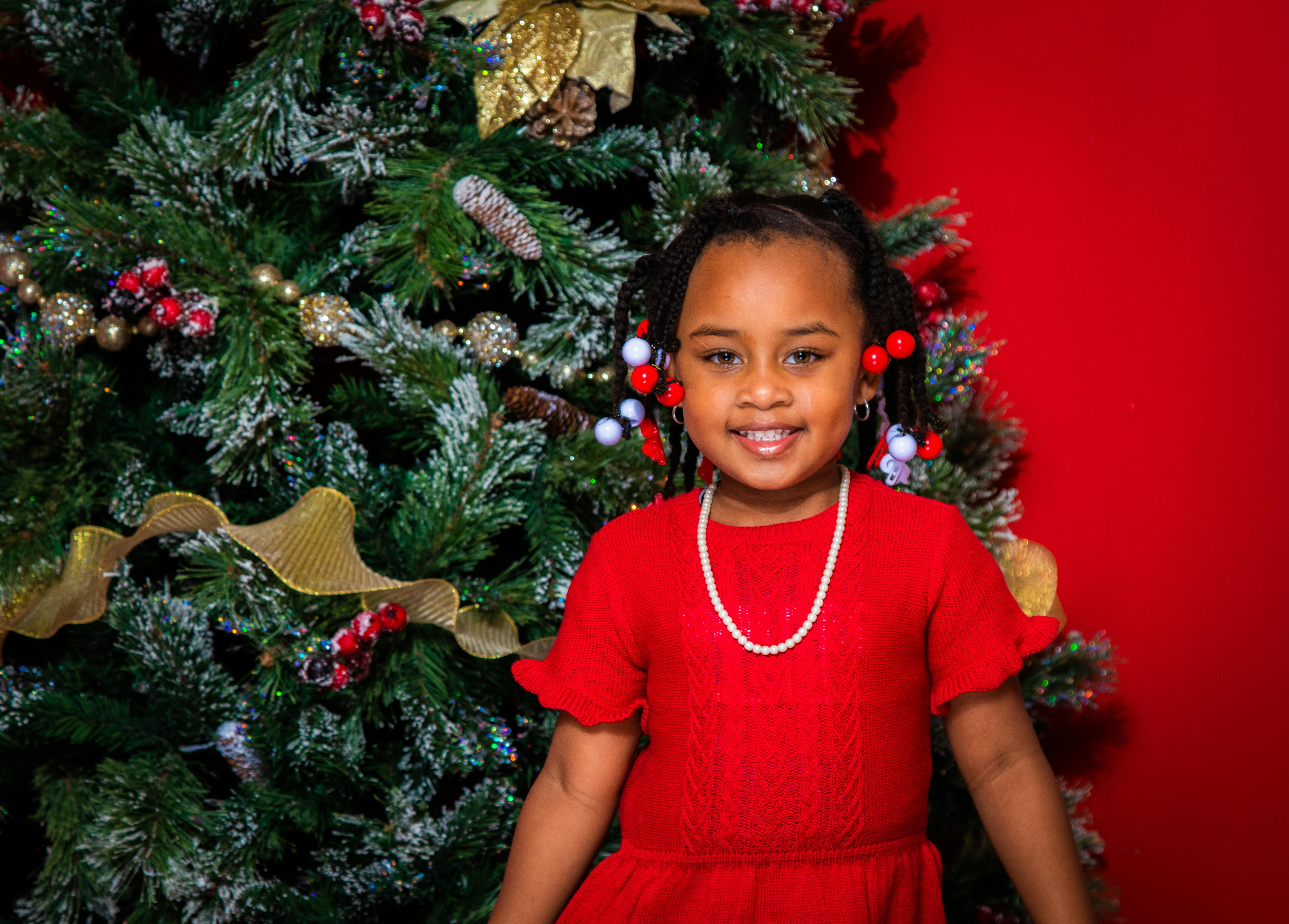 Girl decorating christmas store tree