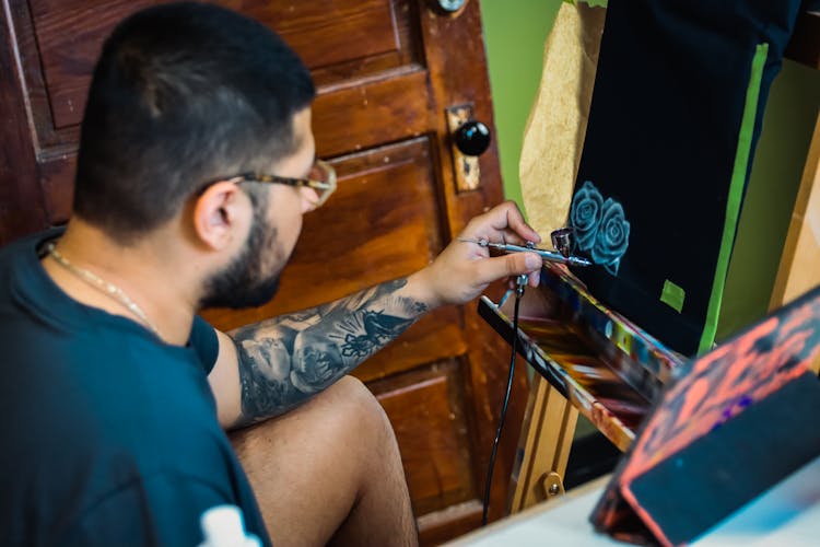 An Artist Creating An Artwork Using An Airbrush Gun