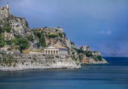 White and Brown Concrete Building on Cliff by the Sea Under Blue Sky