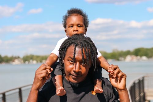 Free A joyful moment of a father carrying his son on shoulders by Walled Lake, MI. Stock Photo