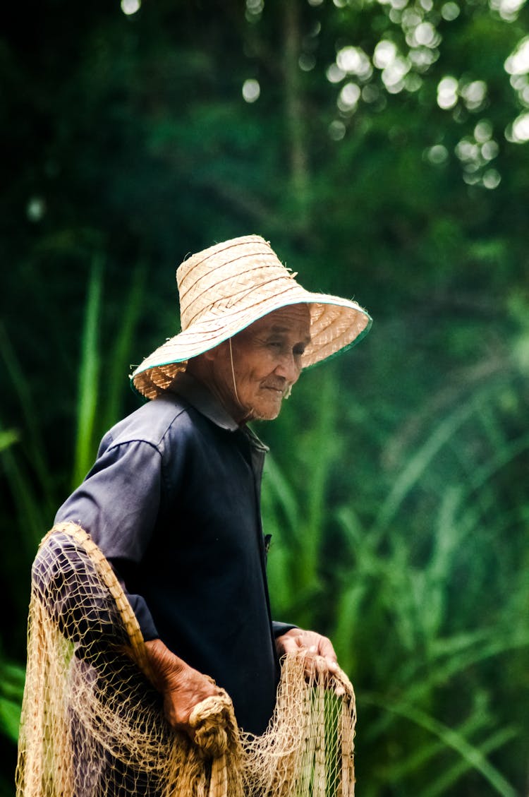 Asian Senior Woman With Fishing Net On Natural Background