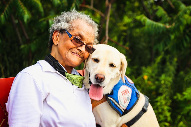 Elderly Woman Sitting Beside A Dog