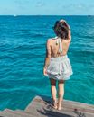 Woman in White Spaghetti Strap Dress Standing on Wooden Dock