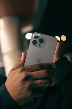Close-up shot of a hand holding a smartphone with a blurred background, capturing a modern lifestyle moment.