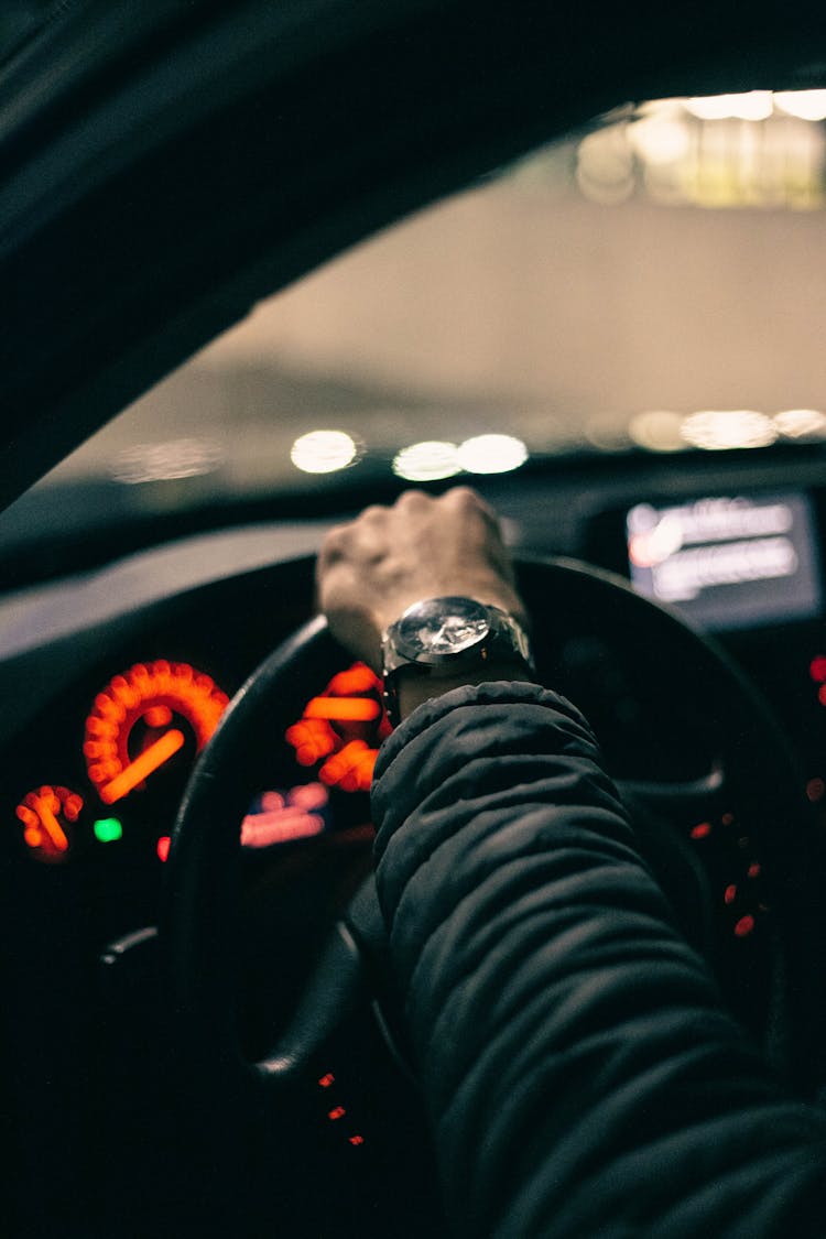 Close-up Of Hand On Steering Wheel In Car