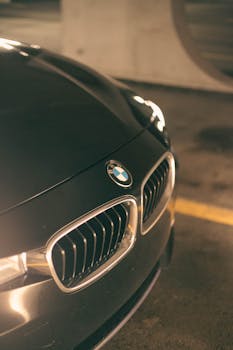 Elegant close-up of a luxury car with a focus on the chrome grill and iconic logo in an indoor setting.