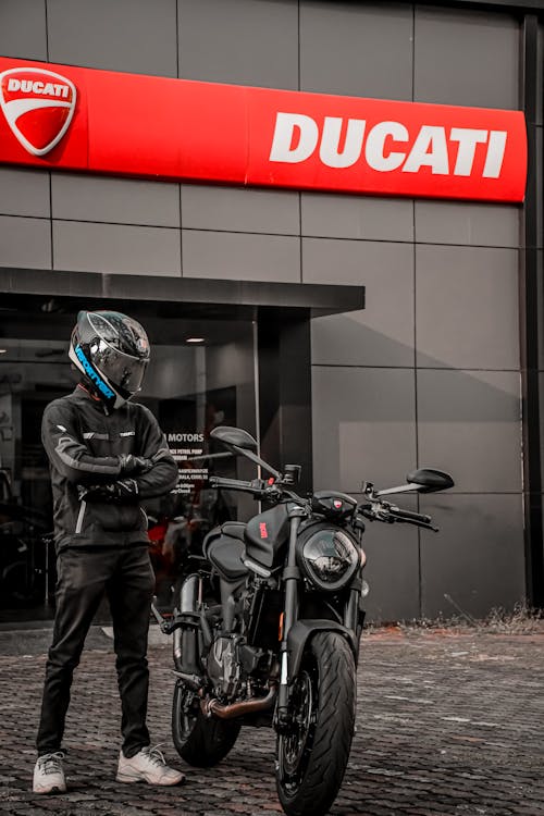 Person Wearing Helmet Standing Beside a Motorbike