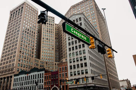 Low-angle view of Detroit skyscrapers and Congress street sign, capturing the urban essence of downtown.