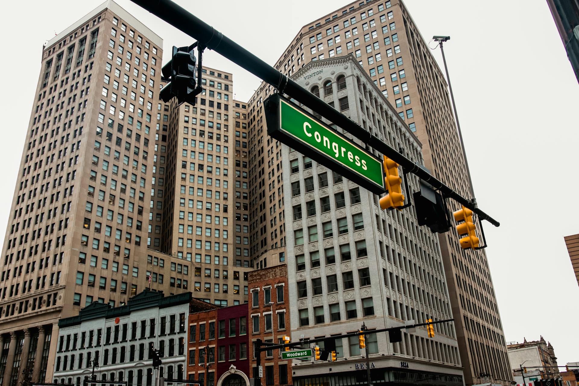 Low-angle view of Detroit skyscrapers and Congress street sign, capturing the urban essence of downtown.