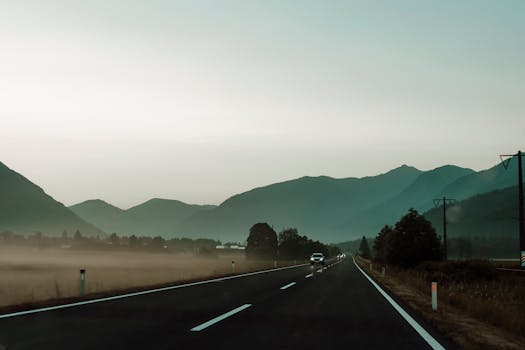 Beautiful foggy road in Kärnten, Austria, with a backdrop of mountains at dawn. Ideal travel and nature scene.