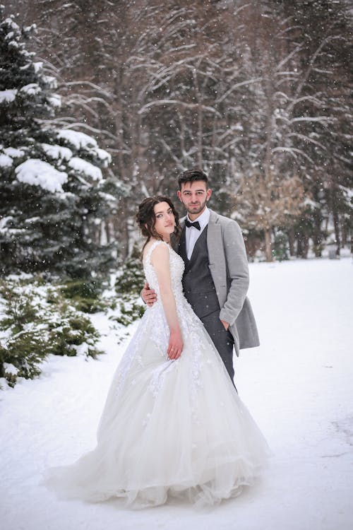 Free Bride and Groom Standing on Snow Covered Ground Stock Photo