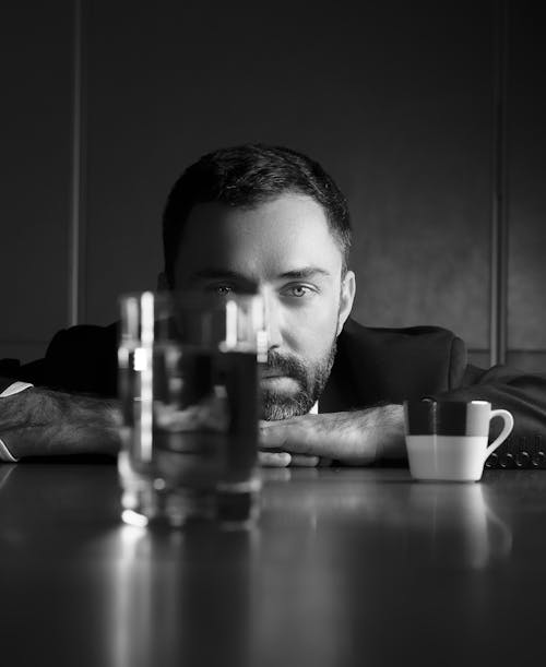 Grayscale Photo of Man Holding Drinking Glass