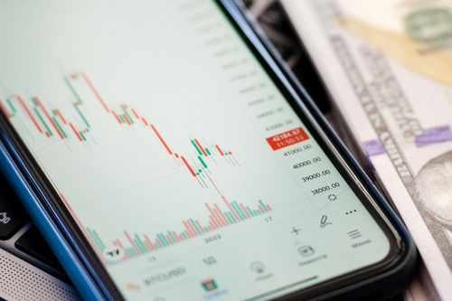 Free Detailed view of stock market data on a smartphone with US dollars in the background, illustrating trading. Stock Photo