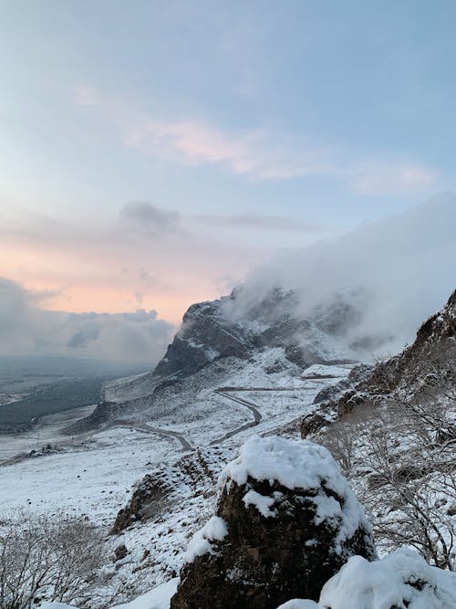 Snow-Covered Mountains under the Cloudy Sky