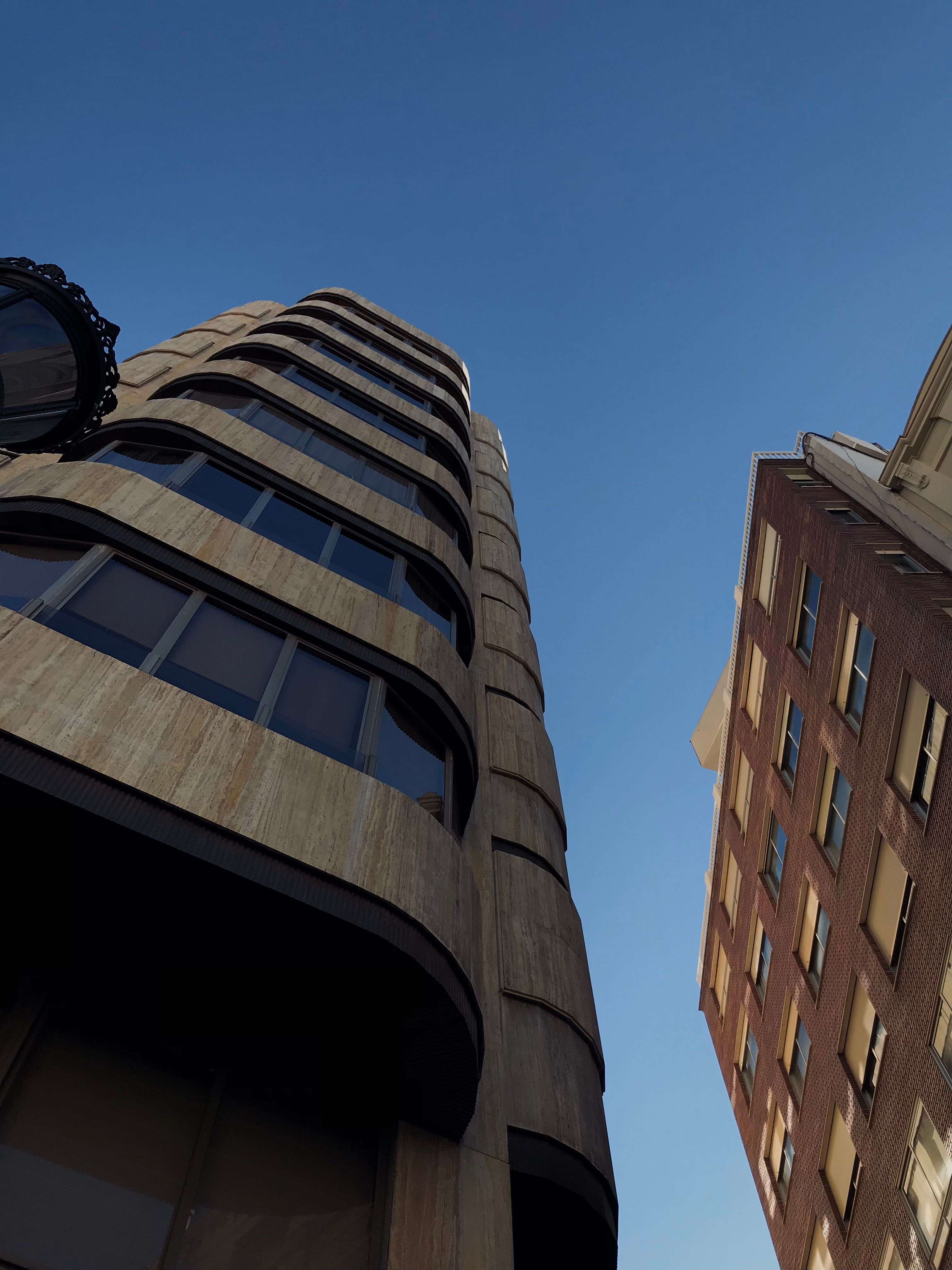 Low-Angle Shot of Concrete Buildings under the Blue Sky · Free Stock Photo