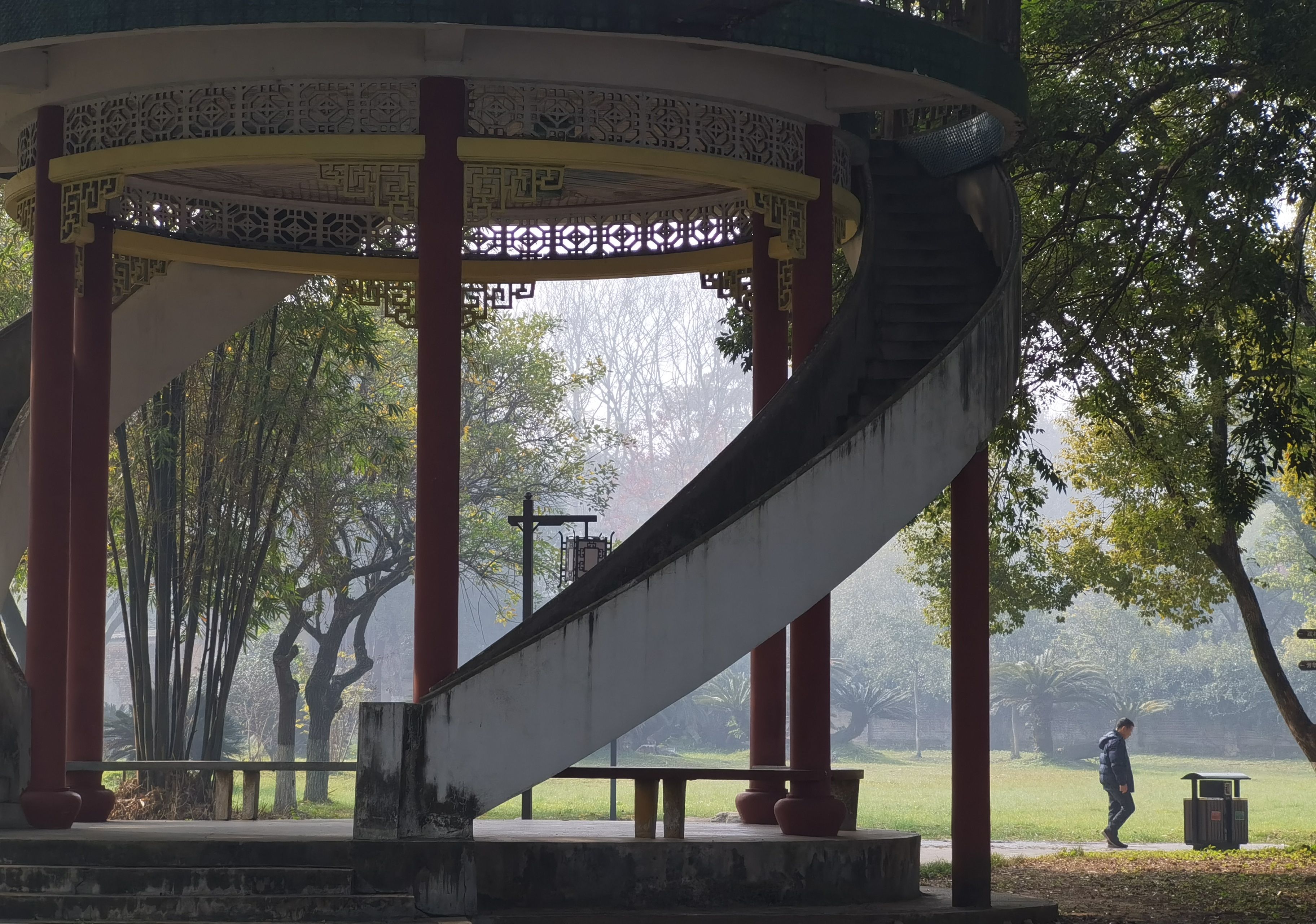 Captivating view of a traditional Chinese gazebo amidst a tranquil park with misty surroundings.