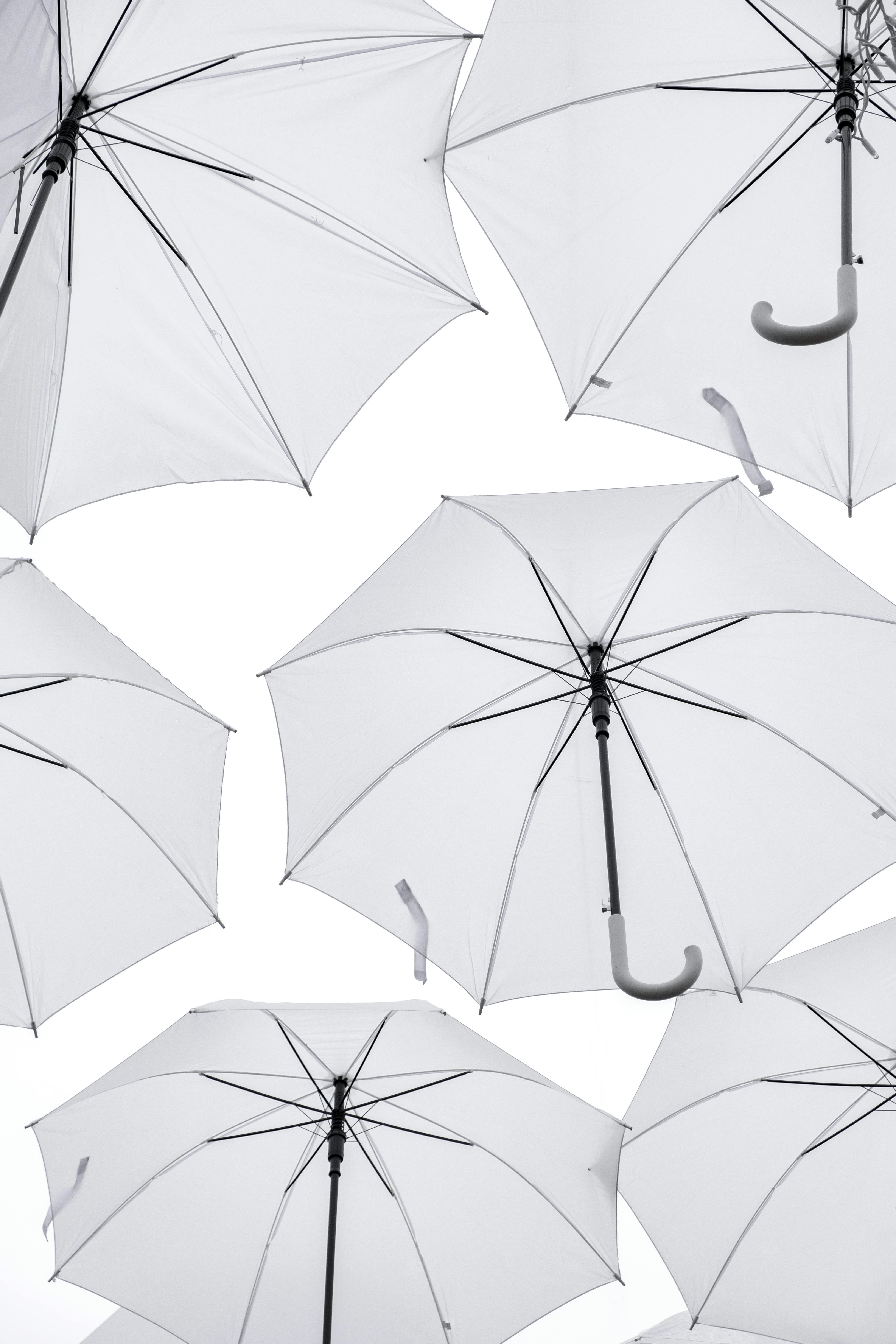 Captivating display of white umbrellas in Paris with a striking bright background.