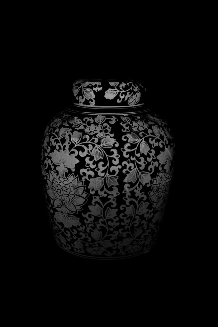Patterned ceramic jar lit against a black ground — photo by Allec Gomes on Pexels