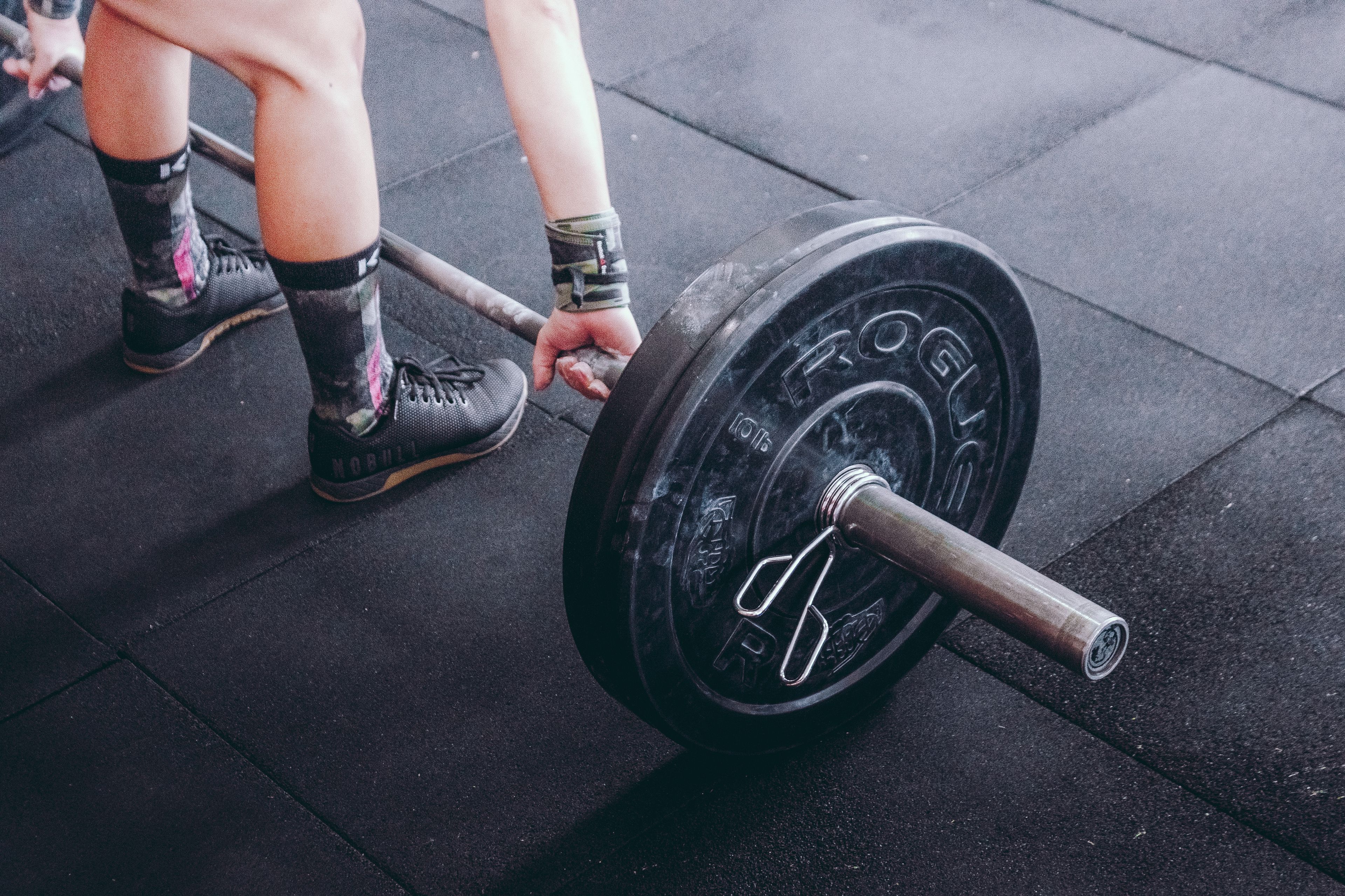 Focused shot of a person lifting a barbell, highlighting strength and fitness.