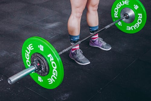 Free Person Standing in Front of Green and Gray Barbell Stock Photo