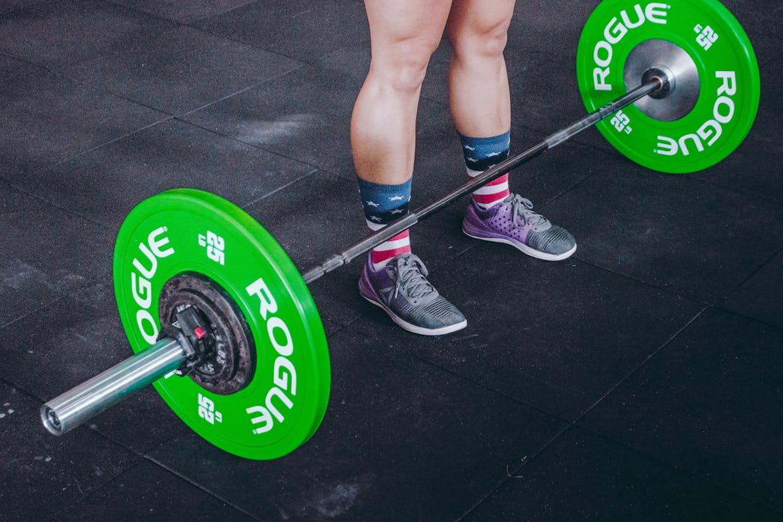 Person Standing in Front of Green and Gray Barbell