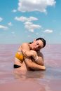 Woman in Yellow Bikini Top Kissing Mans Cheek on Beach