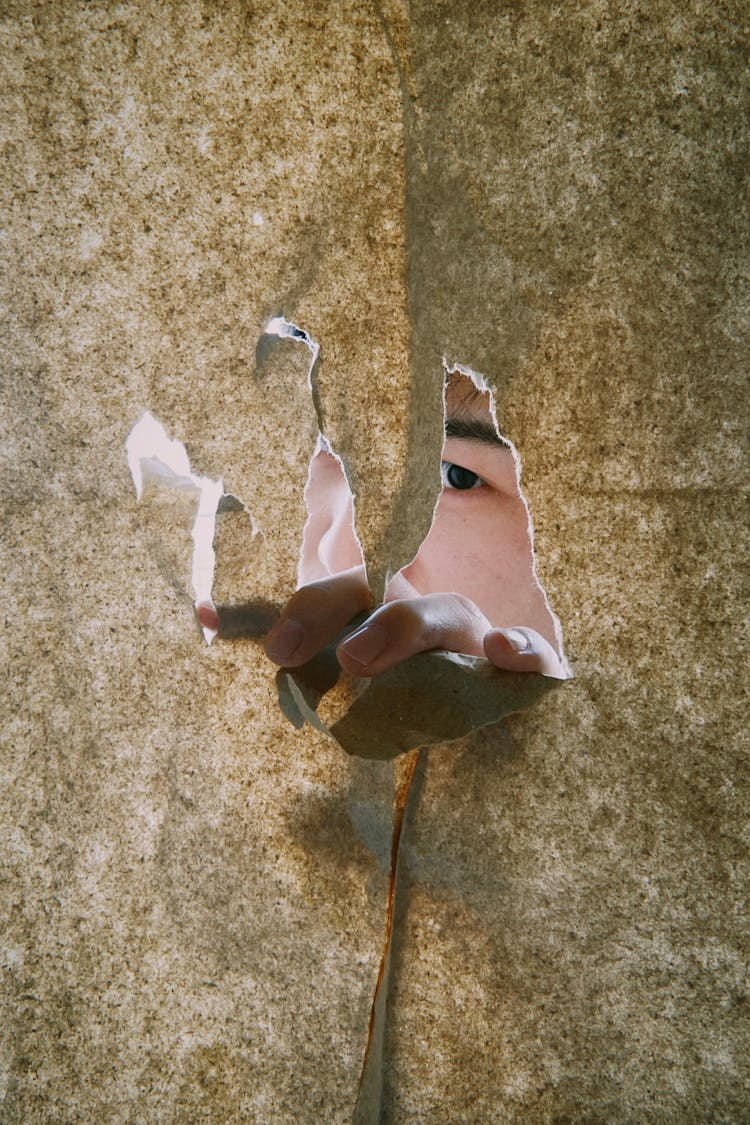 Person Looking Through Hole In Paper