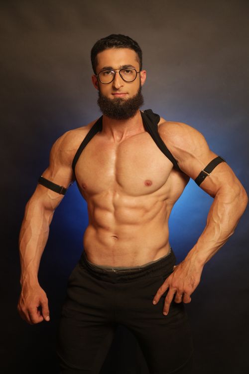 Free A muscular man posing shirtless with eyeglasses, showcasing fitness and strength. Stock Photo