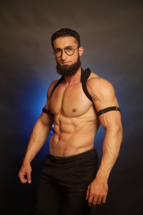 Free A bearded bodybuilder showcasing his muscles with confidence in a studio setting. Stock Photo