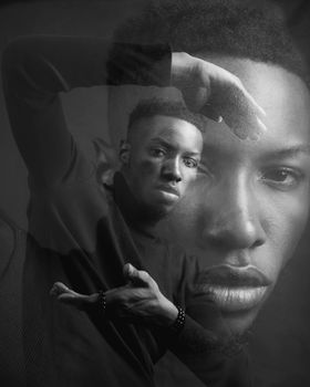 Artistic black and white double exposure portrait of a man with gesturing pose.