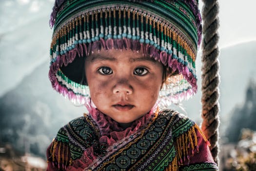 Close-up of a Vietnamese child in traditional attire with a colorful hat, highlighting cultural heritage.