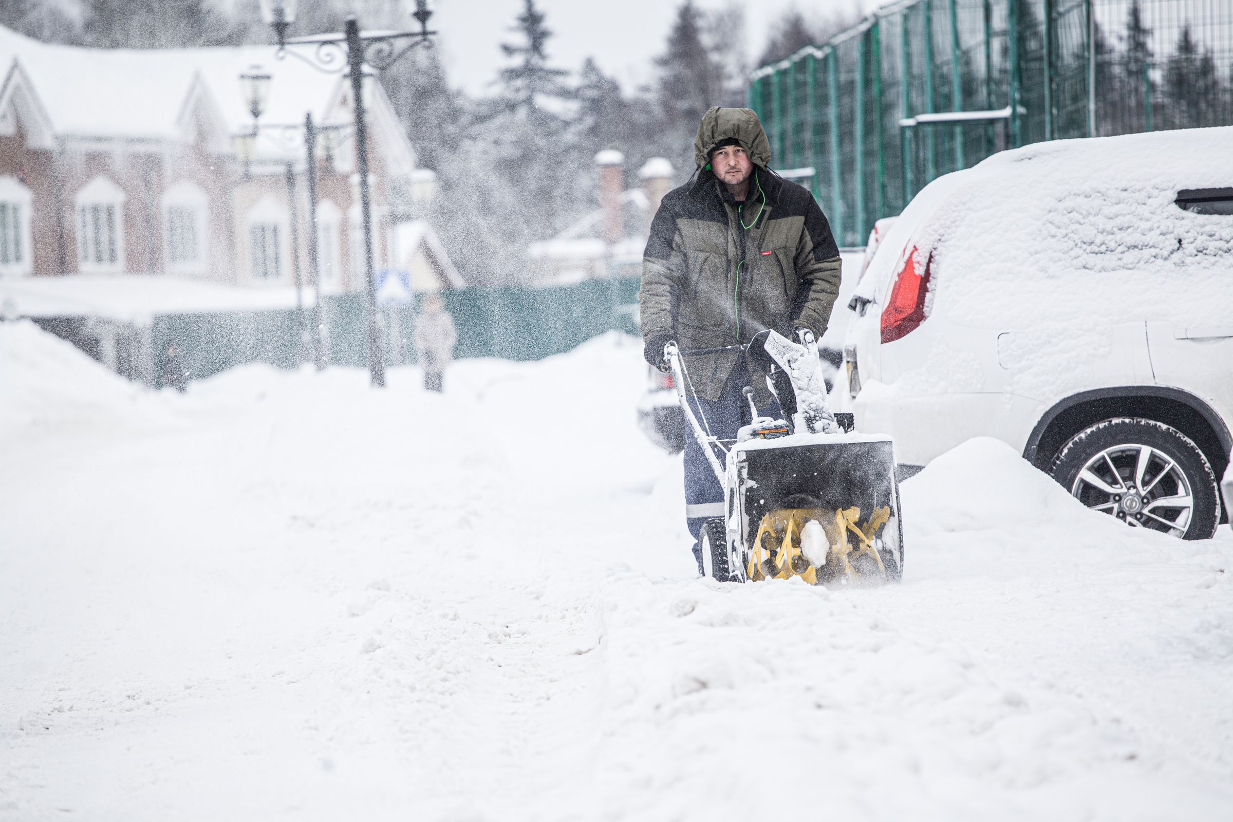 Snowblower clearing a snow-covered residential area