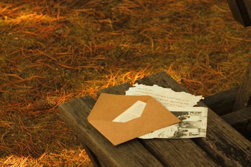 Free Letters and a Brown Envelope on a Wooden Bench Stock Photo