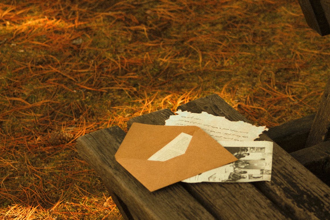 Free Letters and a Brown Envelope on a Wooden Bench Stock Photo