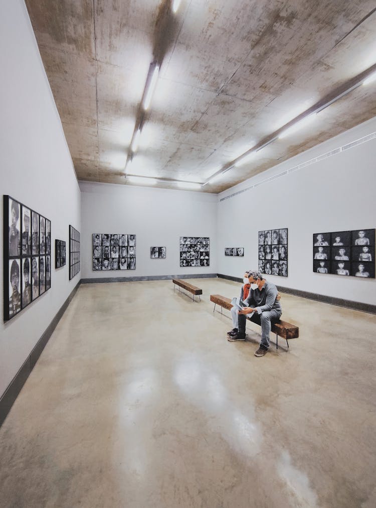 A Couple Sitting On The Bench In The O Conflito Section Of The Galeria Claudia Andujar