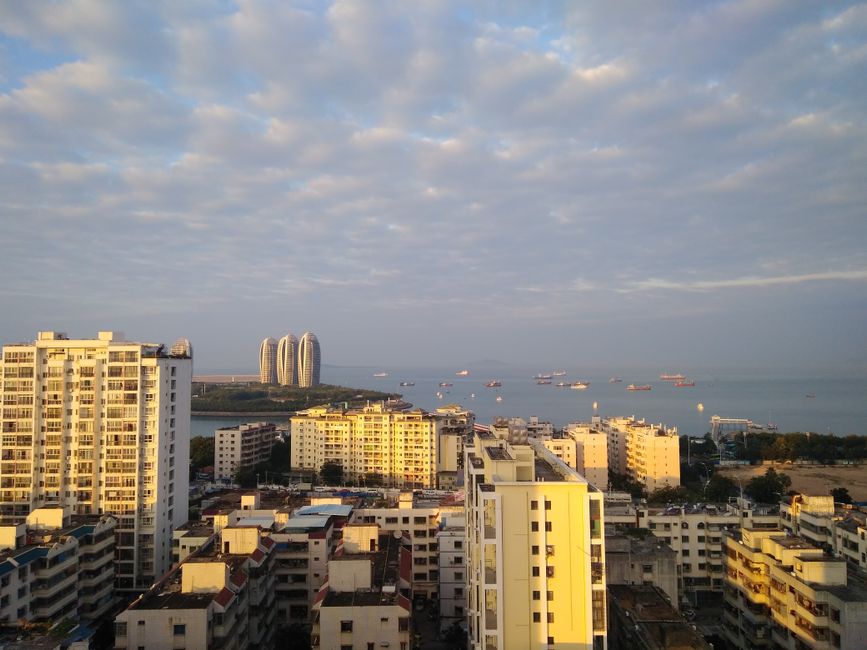 Stunning aerial view of Sanya Bay with the iconic Phoenix Island buildings on a sunny day.