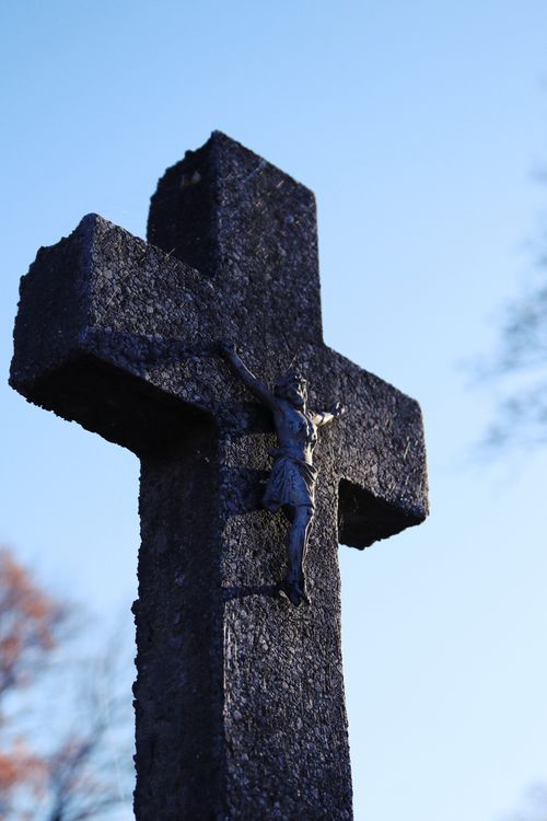 Free Low angle view of a stone crucifix against a bright blue sky. Stock Photo