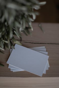Close-up of a stack of blank business cards on a wooden table, offering ample copyspace.