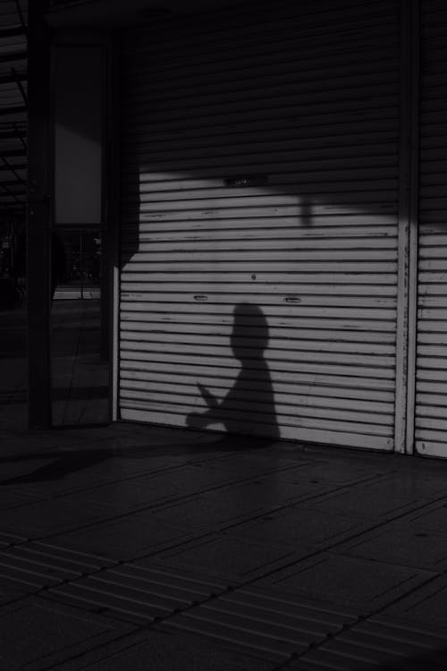 Free A Shadow of a Person on a Roller Shutter Stock Photo