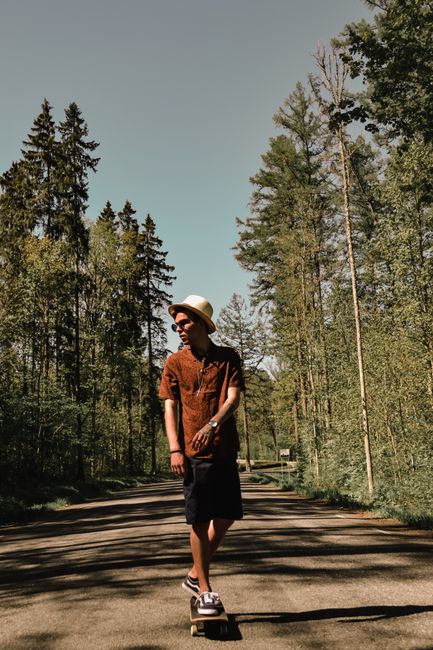 A young man skateboards on a forest road in Viljandi, Estonia, on a fall day.