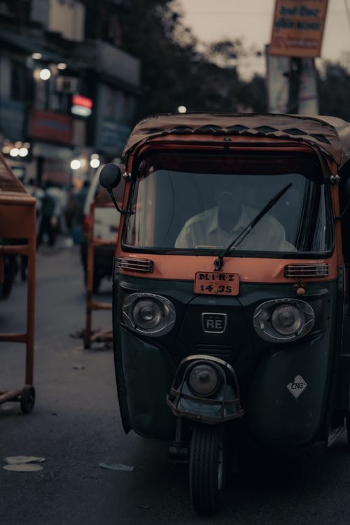Free A tuk tuk with driver in an urban street setting during twilight in India. Stock Photo