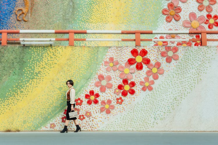 Woman Walking By A Flower Mural